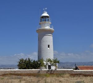 Lighthouse by sea against sky