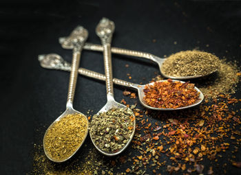 Close-up of seasoning in spoons on table