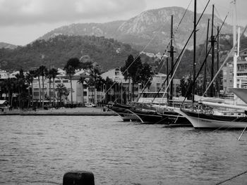 Boats moored in calm sea with buildings in background