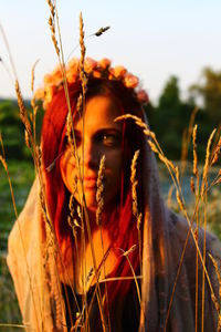 Close-up of woman with plants against sky