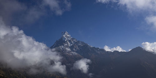 Low angle view of snowcapped mountains against sky