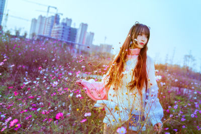 Woman standing amidst flowering plants