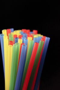 Close-up of colored pencils over black background