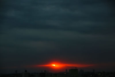 Storm clouds over city during sunset