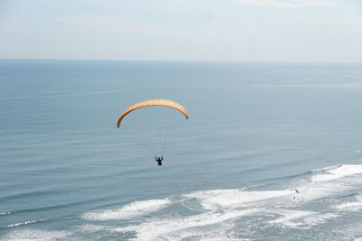 People flying over sea against sky