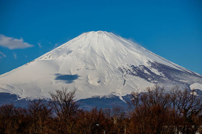 Scenic view of snowcapped mountains against blue sky