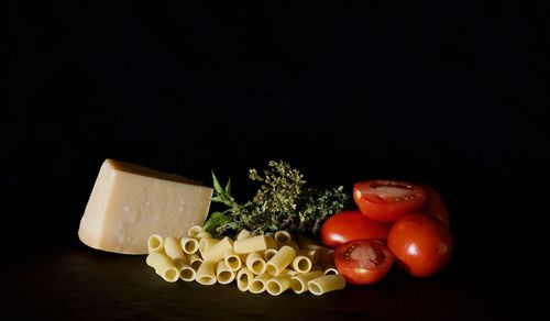 Close-up of fruits on table against black background