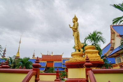 Statue against temple building against sky