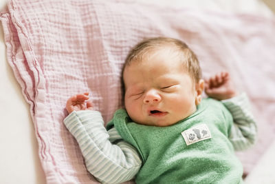 High angle view of baby sleeping on bed