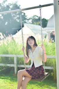 Young woman swinging at playground