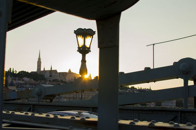 Street light against sky in city during sunset