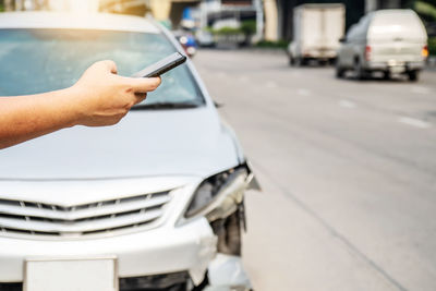 Midsection of man holding car on road