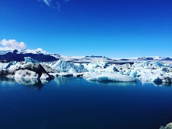 Scenic view of frozen lake against clear blue sky