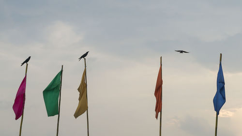 Low angle view of flags hanging against sky