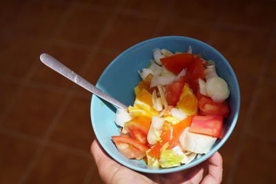 Cropped image of person holding breakfast in bowl on table