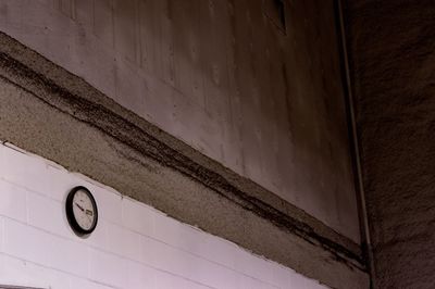 Low angle view of clock on wall in building