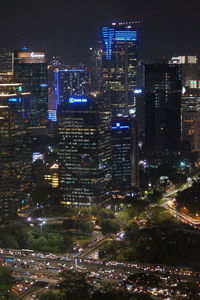 High angle view of illuminated street amidst buildings at night