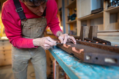 Midsection of man working at workshop