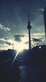 Sun shining through clouds over city