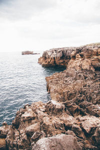 Rock formations by sea against sky