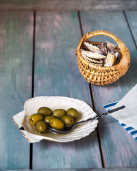 Olives in a flat sink and a wicker basket with sea shells