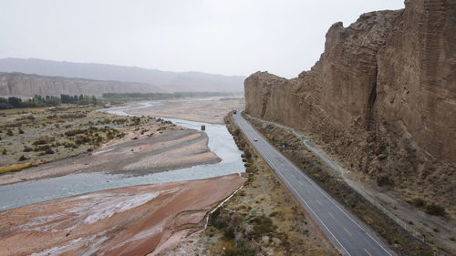 Scenic view of road leading towards mountains against sky