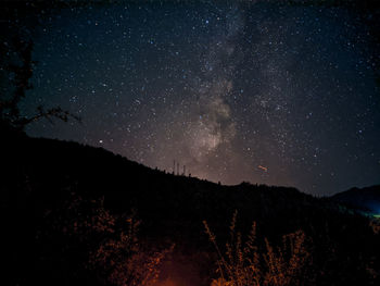 Scenic view of silhouette mountain against sky at night