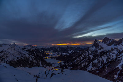 Scenic view of snowcapped mountains against sky during sunset
