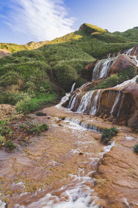 Scenic view of waterfall against sky