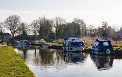 Boats moored in lake against sky