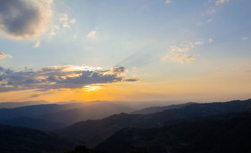 Scenic view of silhouette mountains against sky during sunset