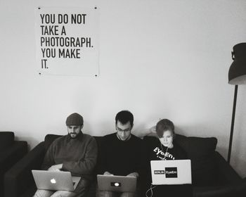 People using laptop while sitting on sofa