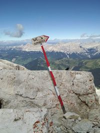 Information sign on mountain against sky