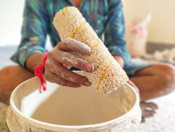 A painter holds a paint roller. painting the wall with a paint roller.