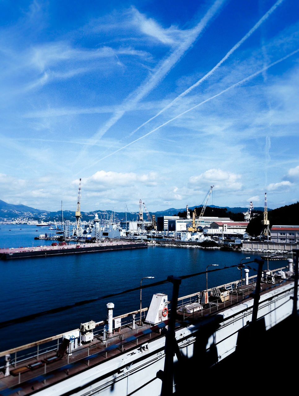 water, sky, blue, railing, sea, built structure, architecture, cloud - sky, nautical vessel, men, connection, city, lifestyles, river, leisure activity, cloud, transportation, person, outdoors