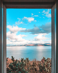 Scenic view of sea against sky seen through window