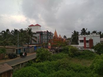 Houses and trees in city against sky