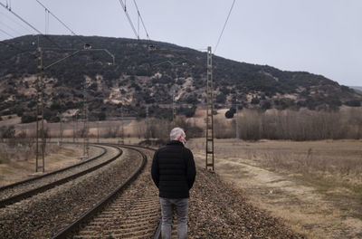 Adult man in warm clothing with railway in countryside. shot in castilla la mancha, spain