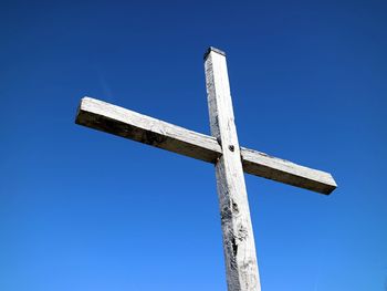 Low angle view of cross against clear blue sky