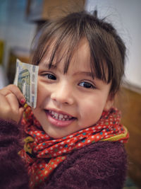 Close-up portrait of smiling woman holding camera
