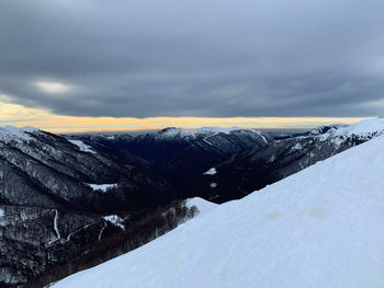 Scenic view of snowcapped mountains against sky during sunset