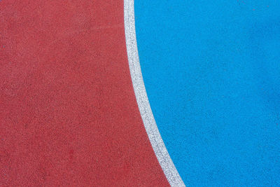 Colorful sports court background. top view to red and blue field rubber ground with  lines outdoors.