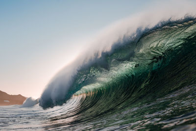 Wave breaking under the sunset on the beach