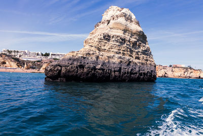 Scenic view of sea against rock formation against sky