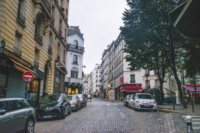 Cars on street amidst buildings in city