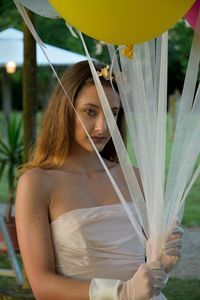 Portrait of young woman holding balloons