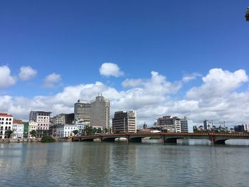 River by buildings in city against sky