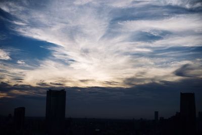 View of cityscape against cloudy sky