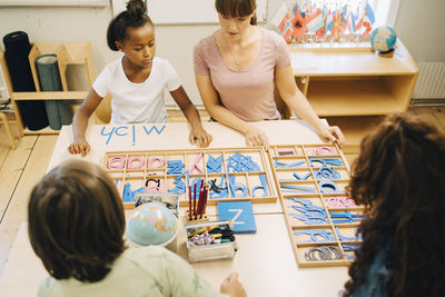 High angle view of teacher teaching spellings to children