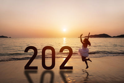 Full length of woman at beach during sunset